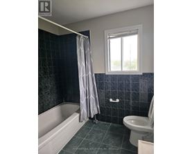A bathroom with a white tub, toilet, and sink.