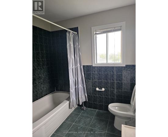 A bathroom with a white tub, toilet, and sink.