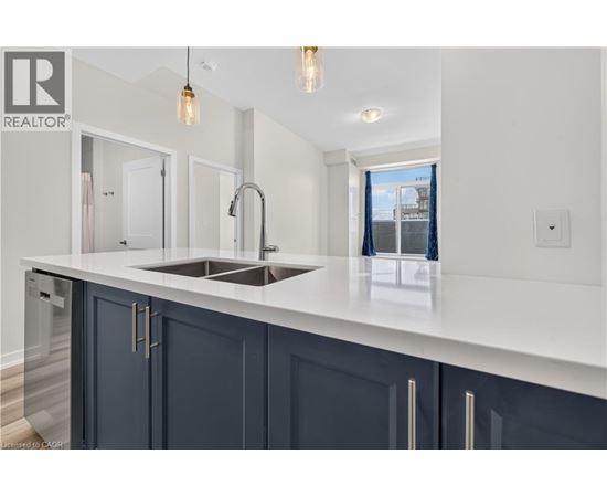 A modern kitchen with dark blue cabinets and a white countertop.