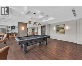 A pool table is in the middle of a room with wood flooring.