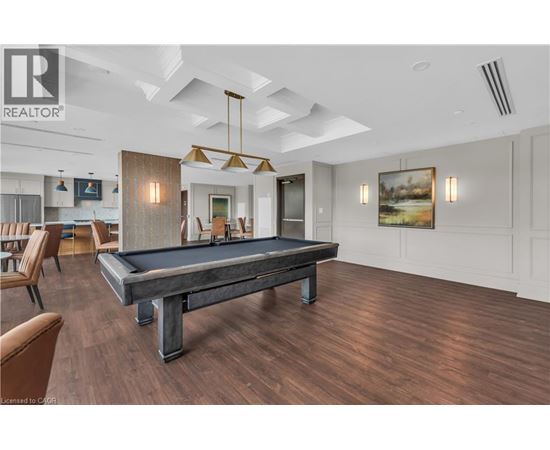 A pool table is in the middle of a room with wood flooring.