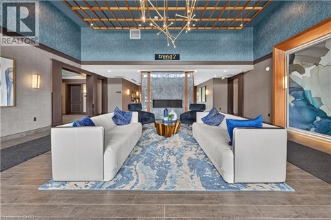 A living room with a white couch and a blue rug.