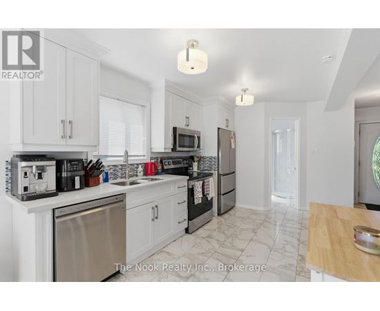 A kitchen with white cabinets and appliances.