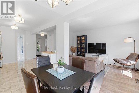 A living room with a black table and brown chairs.