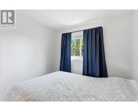 A bedroom with a bed and a window with blue curtains.