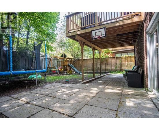A backyard with a basketball hoop and a slide.