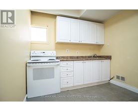 A kitchen with white cabinets and a white stove top oven.