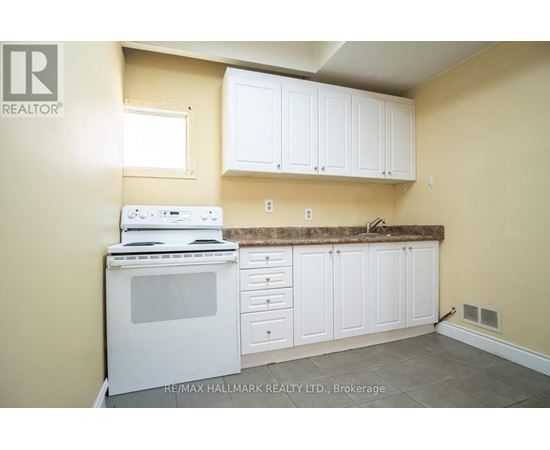 A kitchen with white cabinets and a white stove top oven.