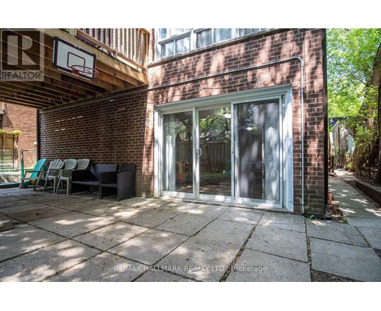 A patio area with a brick wall and a basketball hoop.