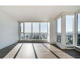 A large empty room with a view of the city through the windows.