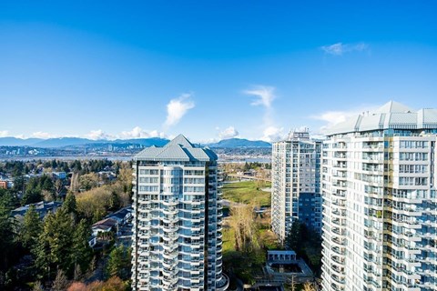 A cityscape with high-rise buildings and a clear blue sky.