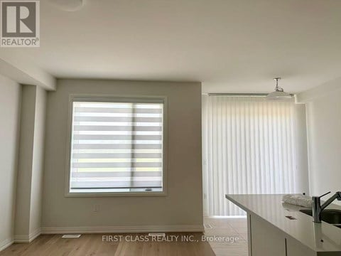 A room with a window covered in blinds and a sink in the corner.