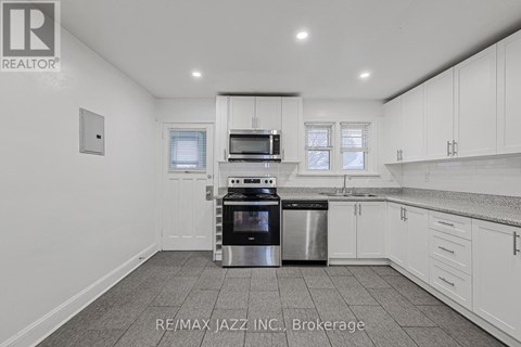 A kitchen with white cabinets and a stainless steel dishwasher and oven.