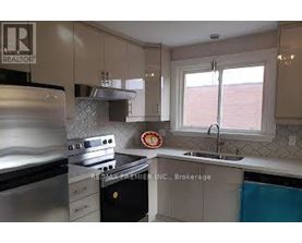 A kitchen with a stove top oven and a sink.