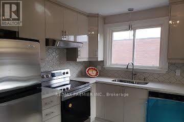 A kitchen with a stove top oven and a sink.