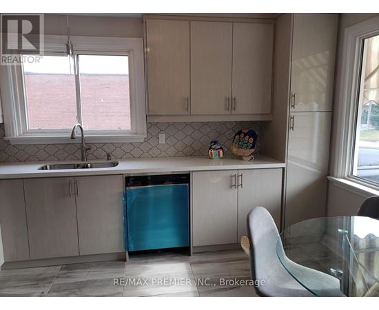 A kitchen with a blue refrigerator and white cabinets.
