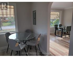 A dining room with a glass table and chairs.