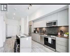 A modern kitchen with stainless steel appliances and white cabinetry.