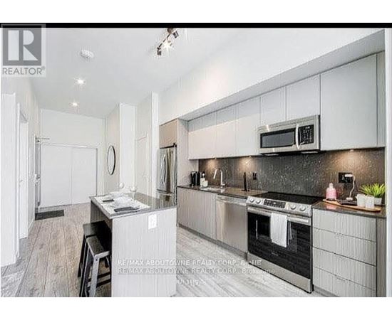 A modern kitchen with stainless steel appliances and white cabinetry.