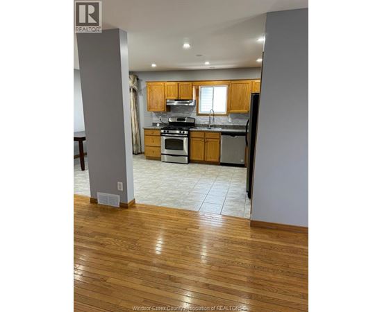 A kitchen with wooden floors and a refrigerator.