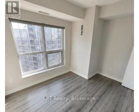 A room with a large window and wooden flooring.