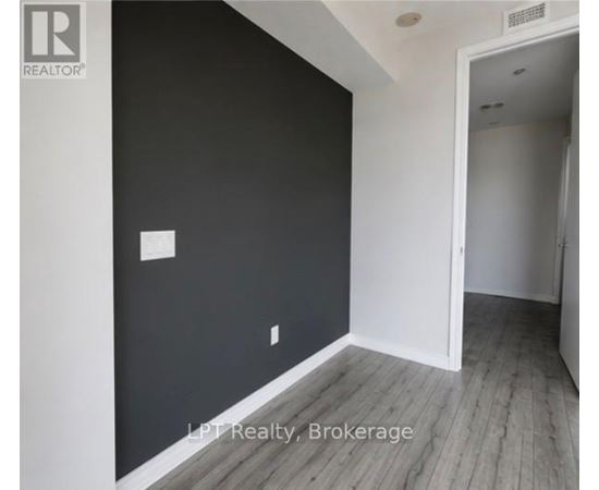 A room with a white door and a black wall.