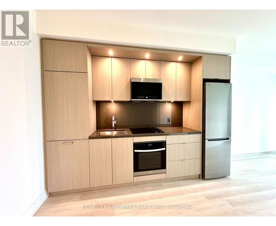 A modern kitchen with wooden cabinets and stainless steel appliances.