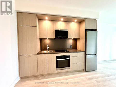 A modern kitchen with wooden cabinets and stainless steel appliances.