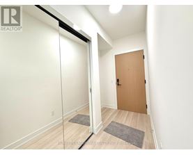 A hallway with a wooden door and a glass door.