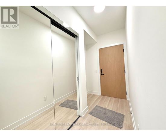 A hallway with a wooden door and a glass door.