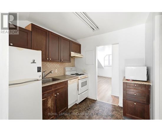 A kitchen with brown cabinets and white appliances.