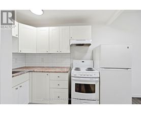 A white kitchen with a stove and refrigerator.