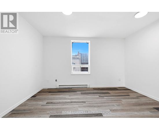 A room with a wooden floor and a picture of a building on the wall.