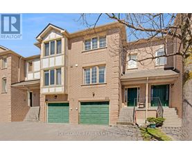 A two-story brick house with a green garage door is for sale.