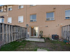 A brown building with a fence and a small patio area.