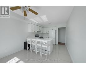 A white kitchen with a table and chairs.