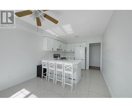 A white kitchen with a table and chairs.