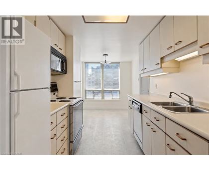A kitchen with white cabinets and a black microwave.