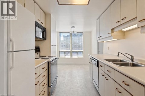 A kitchen with white cabinets and a black microwave.