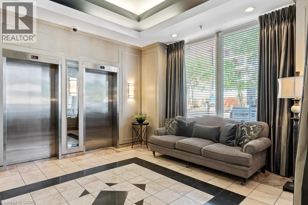 A living room with a grey couch and a black and white checkered floor.