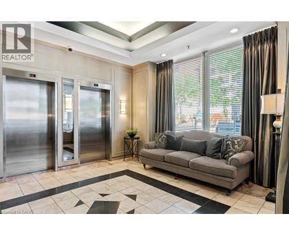 A living room with a grey couch and a black and white checkered floor.