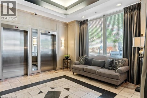 A living room with a grey couch and a black and white checkered floor.