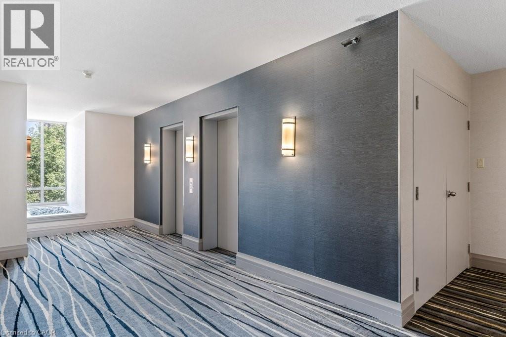 A hallway with a blue carpet and grey walls.