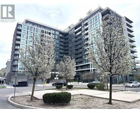 A modern apartment building with a parking lot in front.