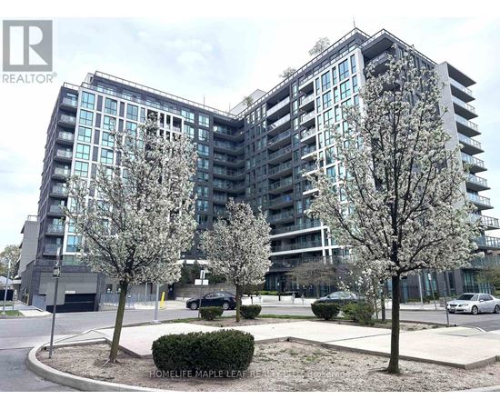 A modern apartment building with a parking lot in front.