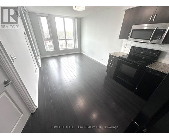 A kitchen with black cabinets and a stove top oven.