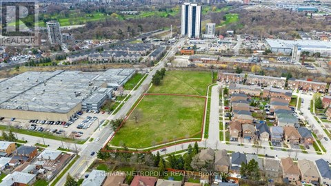 An aerial view of a city with a large green space in the foreground and buildings in the background.