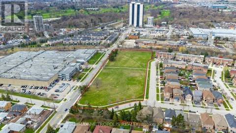 An aerial view of a city with a large green space in the foreground and buildings in the background.
