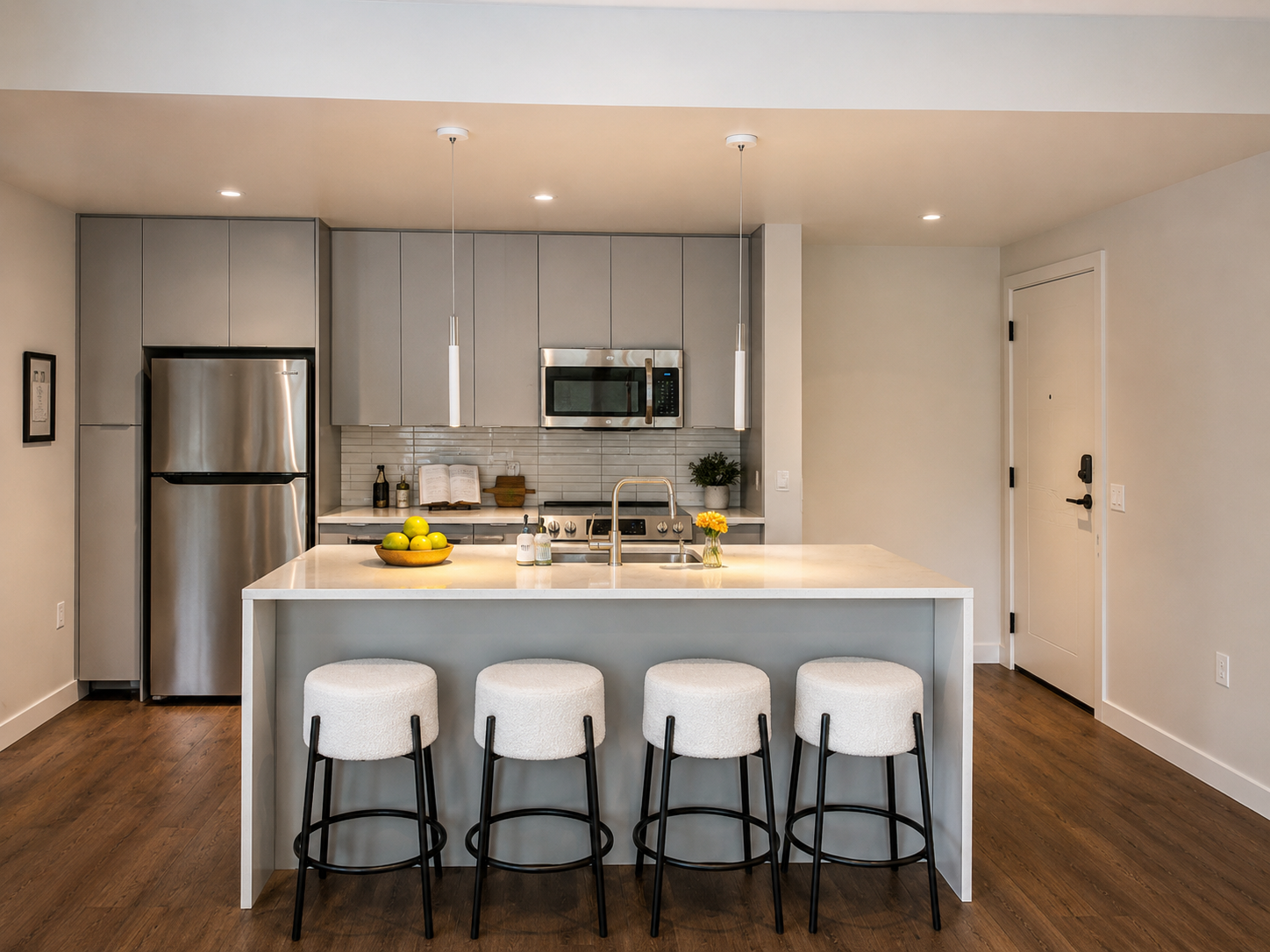 A modern kitchen with a white island and bar stools.