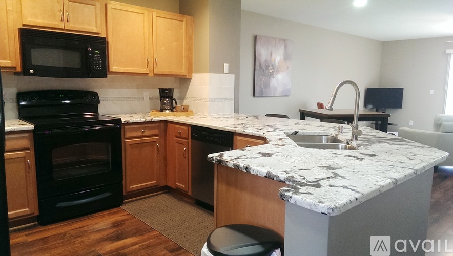 A kitchen with wooden cabinets and black appliances.
